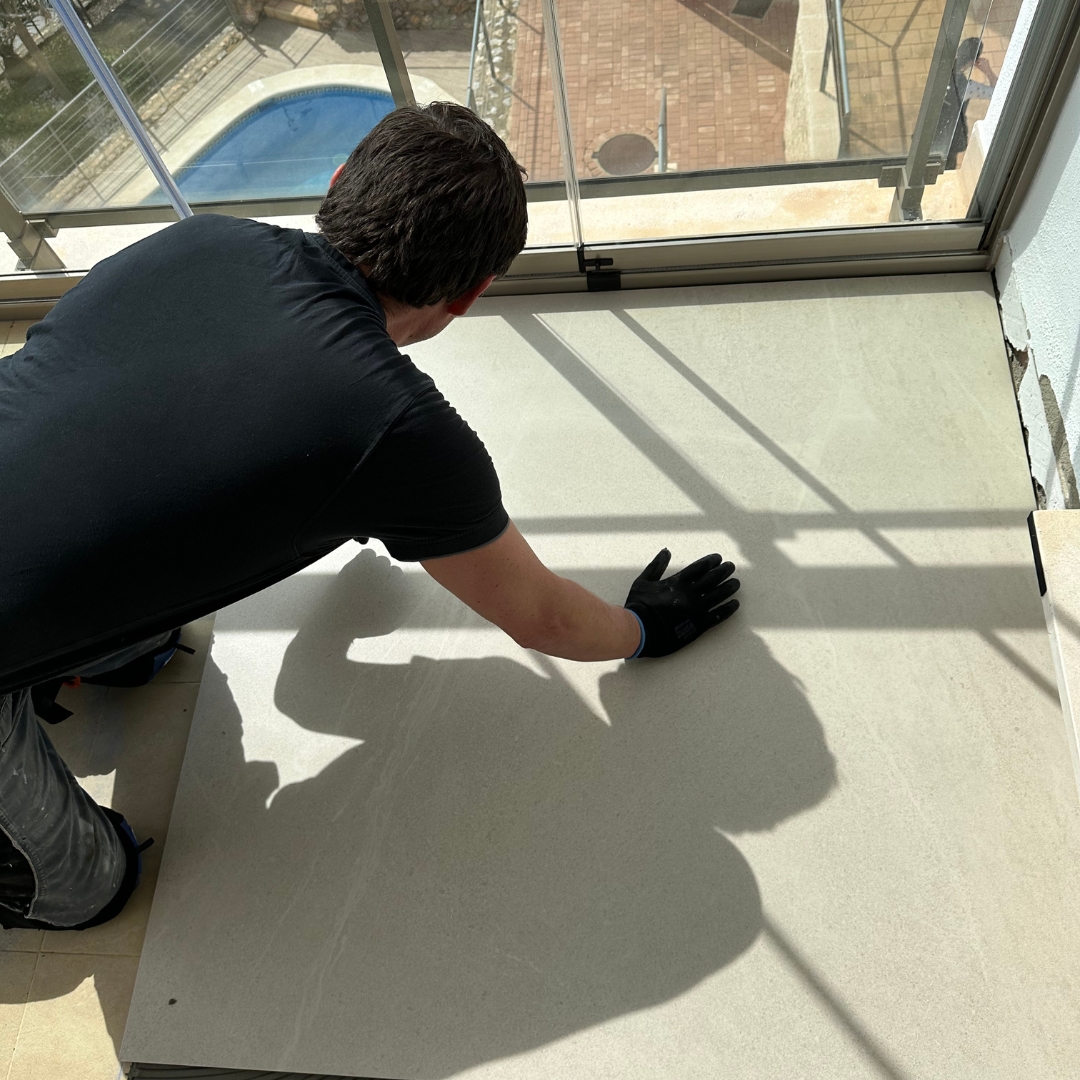 Eugen Krüger verlegt Fliesen auf einer Terrasse im 3 Stock.